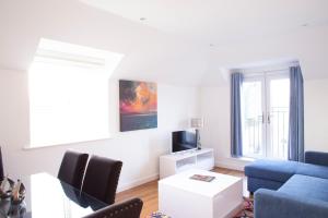 a living room with a blue couch and a tv at Savoy Court - Free Parking in Bristol