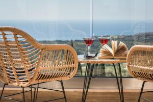 - une table avec deux chaises et deux verres de vin dans l'établissement Diana Suites, à Trapezaki