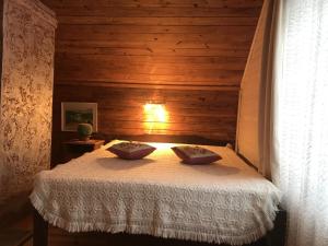 1 dormitorio con 1 cama en una habitación de madera en Mäe Farm en Rõuge