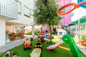 un parque de juegos con coches de juguete y un tren de juguete en Hotel Di Giovanni en Bibione