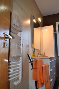 a bathroom with orange towels hanging on a wall at Casinha do Eido Novo - Alojamento Local in Valença