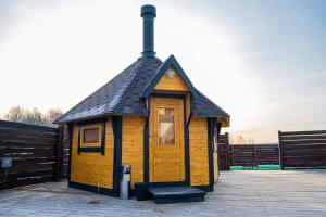 a small wooden building with a black roof at Usadba Romashkovo Hotel in Romashkovo