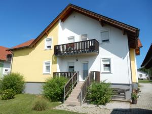 a yellow and white house with a balcony at Appartement Huber in Lutzmannsburg
