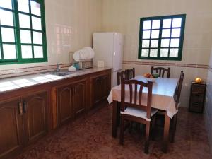 a kitchen with a table and a white refrigerator at Casa Vista Bella in El Cercado