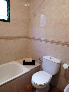 a bathroom with a toilet and a tub and a sink at Casa Vista Bella in El Cercado