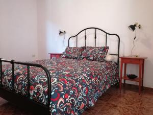 1 dormitorio con 1 cama con edredón rojo y negro en Casa Vista Bella, en El Cercado