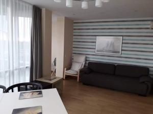 a living room with a couch and a table at Elijos apartamentai in Šventoji