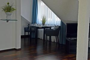 a dining room with a table with chairs and a television at Hotel Quisisana & Appartements Quisi in Helgoland