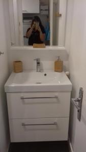 SUPERDEVOLUY STUDIO au 433S في لو ديفولي: امرأة التقطت صورة لمغسلة الحمام