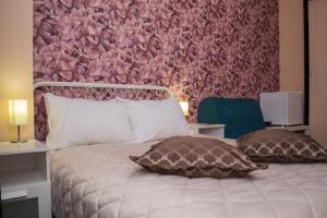 a bed with two pillows and a pink wall at Hotel Tverskaya 5 in Moscow
