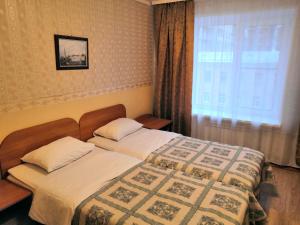 A bed or beds in a room at Kievskaya Hotel on Kurskaya