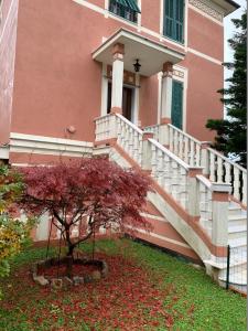 una casa rosa con una scala di fronte di Resort Villa Rosa Maria a Savona