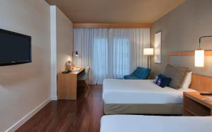 a hotel room with a bed and a television at Mercure Campinas in Campinas