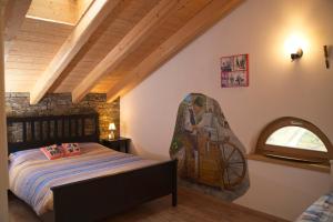 a bedroom with a bed with a painting on the wall at B&B Ai Marchetini in Cinte Tesino