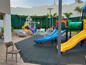une aire de jeux avec des enfants jouant sur un toboggan dans l'établissement Apartamento em Resort de Olimpia, à Olímpia