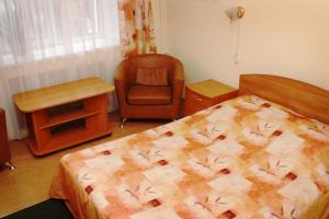 1 dormitorio con cama, silla y escritorio en Lyuks Hotel, en Kirov