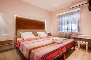 a bedroom with a bed and a window at Nissaki Suite Poseidon by Sealand Villas in Nisakion