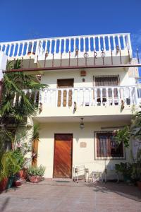 a white house with a red door and a balcony at Cancun Guest House 4 Terrace Tub in Cancún