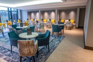 a waiting room with tables and chairs in a building at Crow Wood Hotel & Spa Resort in Burnley