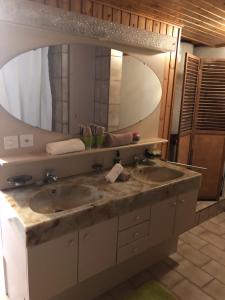 ein Badezimmer mit zwei Waschbecken und einem großen Spiegel in der Unterkunft Appart'Hôtel HG in Pruntrut