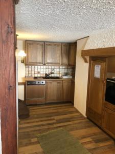 eine Küche mit Holzschränken und einer Spüle in der Unterkunft Appart'Hôtel HG in Pruntrut