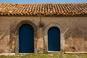three blue doors on the side of a building at Fontanarossa in Cerda