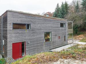 una casa gris con una puerta roja en una colina en Splendid Holiday Home in Freital with Sauna, en Freital