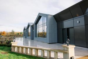 a modern house with glass windows and a bench at Crow Wood Hotel & Spa Resort in Burnley