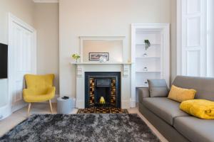 uma sala de estar com um sofá e uma lareira em The Polwarth Apartment em Edimburgo