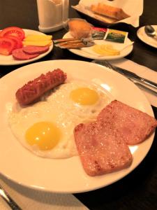 a plate of eggs and bacon and toast on a table at BOUTIQUE HOTEL 1967 AQSAI in Aksay