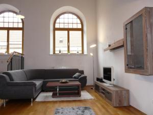 a living room with a couch and a tv at Ferienwohnung Kampenwand-Loft in Aschau im Chiemgau