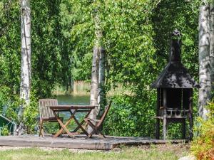 stół i krzesła na drewnianym tarasie z grillem w obiekcie Holiday Home Kaisla by Interhome w mieście Torvoila