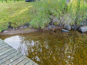 a pond with a wooden bridge in a garden at Holiday Home Iltarauha by Interhome in Ruvaslahti