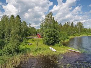 un petit bateau posé sur la rive d'un lac dans l'établissement Holiday Home Pajaranta by Interhome, à Hara