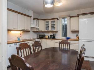 una cucina con tavolo, sedie e frigorifero bianco di Holiday Home Kaisla by Interhome a Torvoila