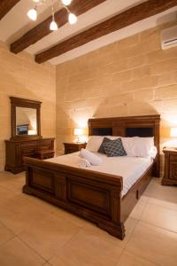 a bedroom with a large bed and a mirror at Valletta Grand Central in Valletta