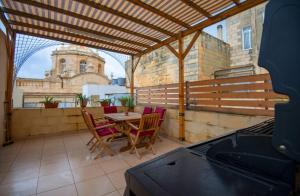 a balcony with a table and chairs and a building at Valletta Grand Central in Valletta