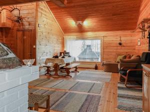 ein Wohnzimmer mit Holzwänden und einem großen Fenster in der Unterkunft Holiday Home Piilola by Interhome in Raanujärvi