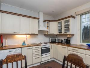 una cucina con mobili bianchi e un forno a piano cottura di Holiday Home Kaisla by Interhome a Torvoila