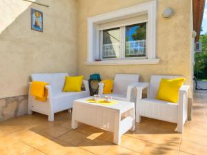 Balcon del MarにあるVilla Eucaliptus by Interhomeのパティオ(椅子、テーブル、黄色い枕付)