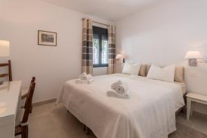 1 dormitorio con 1 cama blanca grande y toallas. en Cozy holiday home in the beach, en Marbella