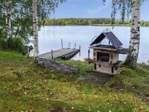 a grill on the side of a lake with a dock at Holiday Home Iltarauha by Interhome in Ruvaslahti