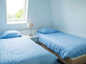 Een bed of bedden in een kamer bij Holiday Home Bungalowparck Tulp & Zee by Interhome