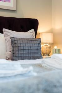 a bed with a pillow and a lamp on a table at The Polwarth Apartment in Edinburgh