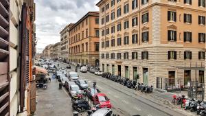 een stadsstraat met geparkeerde auto's en gebouwen bij Relais Cavour Inn in Rome