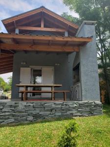 una pequeña casa con una mesa de picnic delante de ella en Duplex 2 dormitorios a mt del rio Brezza di Fiume en Los Reartes