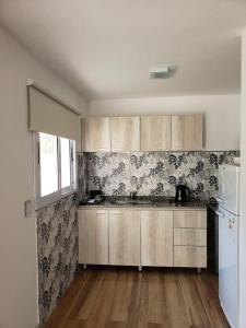 cocina con suelo de madera y nevera blanca en Duplex 2 dormitorios a mt del rio Brezza di Fiume en Los Reartes