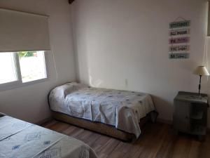 1 dormitorio con 2 camas y ventana en Duplex 2 dormitorios a mt del rio Brezza di Fiume en Los Reartes