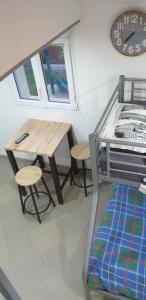 a room with a table and a bed and a table and stool at studio mezzanine 5 personnes in La Roche