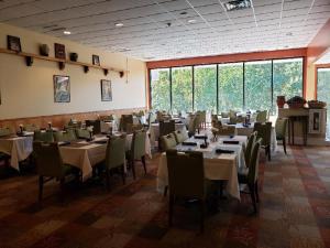 a dining room with tables and chairs and windows at The Chateau Resort in Tannersville